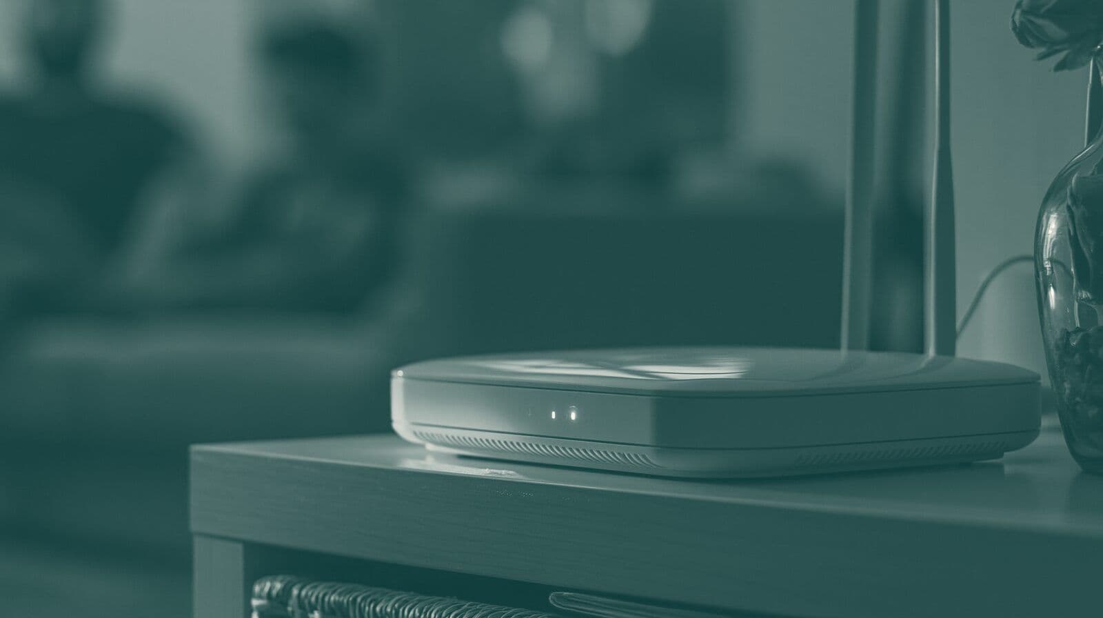 A home broadband router on a side table in a dim living room.
